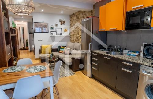 eine Küche und ein Wohnzimmer mit Tisch und Stühlen in der Unterkunft Loft Arco de los zapatos,Casco histórico Oviedo in Oviedo