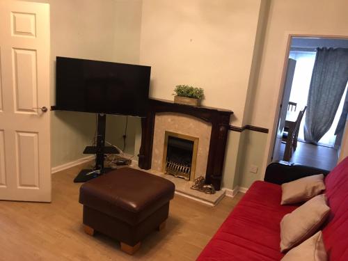a living room with a fireplace and a tv at The Rose in Greasbrough