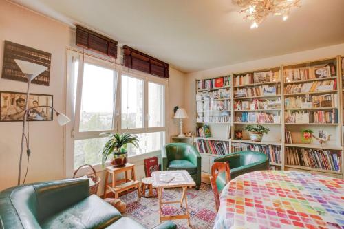 une chambre avec des chaises vertes, une table et des étagères dans l'établissement Aux Portes des Lilas, à Bagnolet