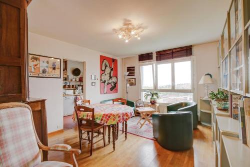 un salon avec une table et des chaises dans l'établissement Aux Portes des Lilas, à Bagnolet