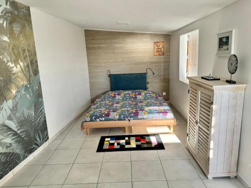 Dormitorio pequeño con cama y mesa en Maeva Sunset, en Saint-Leu