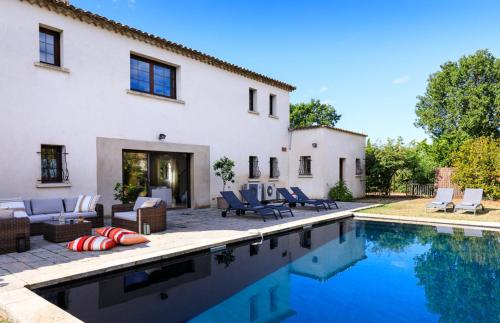 une maison avec une piscine devant une maison dans l'établissement L'Orangerie, à Blauzac