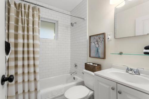 een witte badkamer met een wastafel, een bad en een toilet bij Discover Decatur in Decatur
