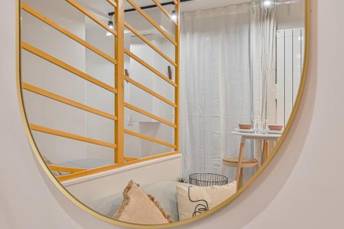 un miroir circulaire reflétant une pièce avec un escalier dans l'établissement Studio Parisien, à Paris