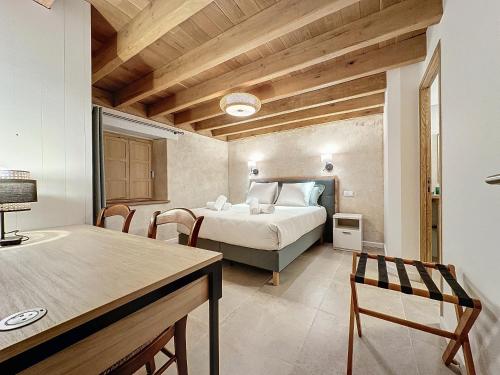 Schlafzimmer mit einem Bett, einem Tisch und Stühlen in der Unterkunft Ty Breignou Coz superbe demeure bretonne in Bourg-Blanc