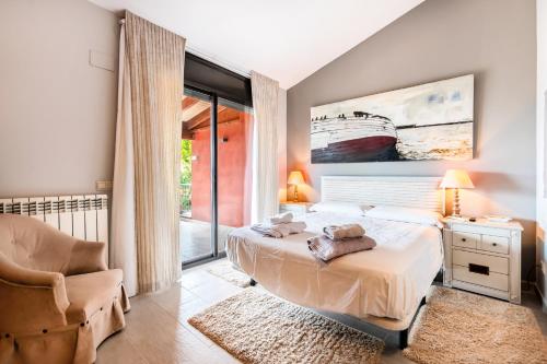 ein Schlafzimmer mit einem Bett und einem Stuhl sowie einem Bett sidx sidx sidx in der Unterkunft Villa Marimar - Private Pool in Bonmont Terres Noves