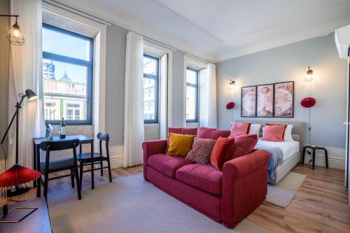 ein Wohnzimmer mit einem roten Sofa und einem Bett in der Unterkunft Sta Catarina 632 by LovelyStay in Porto