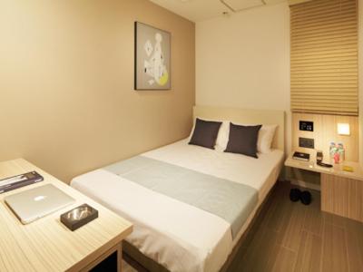 a small bedroom with a bed and a desk at Hotel UNO Nishikawaguchi Nishiguchi in Kawaguchi