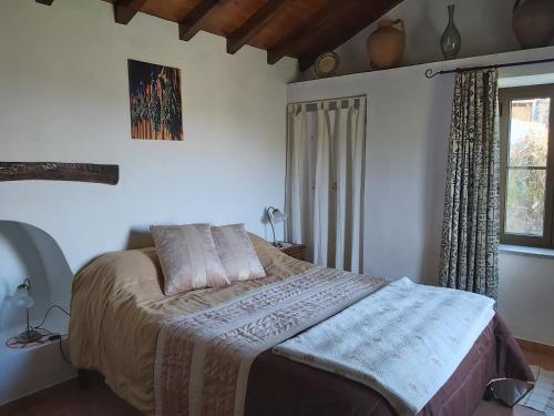 a bedroom with a bed and a window at Casa de Xisto in Arganil