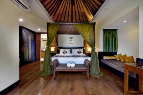 a bedroom with a bed and a couch at The Khayangan Dreams Villa, Seminyak in Seminyak