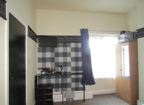 a bathroom with a black and white checkered wall at No12 Guesthouse South Shore Blackpool in Blackpool
