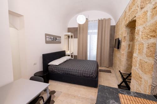 a bedroom with a bed and a brick wall at Santa Lucia Affittacamere in Gioia del Colle