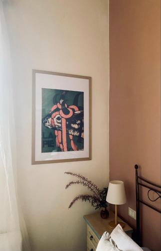a picture hanging on a wall in a bedroom at La Siba Experience in Forlì