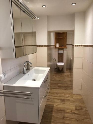a white bathroom with a sink and a toilet at Am Neupersteg - Eine Wohnung zum Wohlfühlen in Bad Aussee