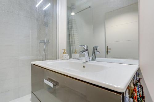 a white bathroom with a sink and a shower at Le Rayon de Soleil de Clamart in Clamart