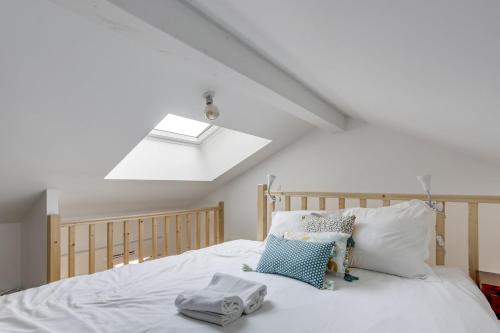 a bedroom with a white bed with a skylight at Le Rayon de Soleil de Clamart in Clamart