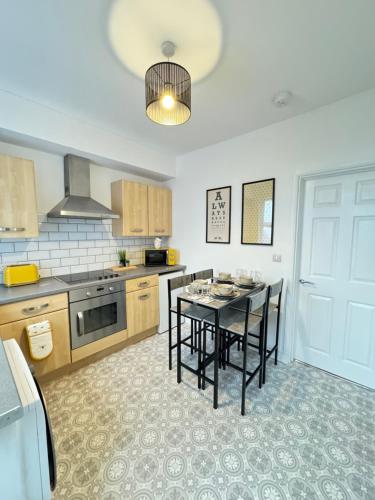 a kitchen with a table and chairs in it at Cosy home in Barnsley centre in Barnsley