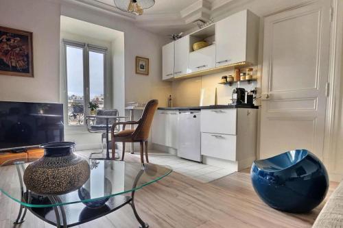 un salon avec une table en verre et une cuisine dans l'établissement APPARTEMENT PARIS 11 Quartier Saint Maur, Oberkampf, à Paris