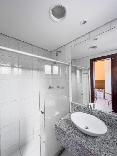 La salle de bains est pourvue d'un lavabo et d'une douche en verre. dans l'établissement Itaparica Praia Hotel, à Itaparica Town
