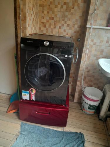 a washing machine in a red box in a bathroom at Suíte confortavel in Rio de Janeiro