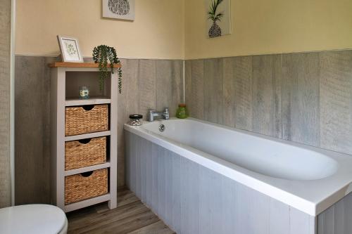 y baño con bañera blanca y aseo. en Finest Retreats - Tan-Y-Dderwen, en Aberhafesp