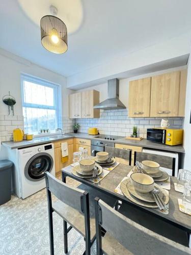 a kitchen with a table with dishes on it at Cosy home in Barnsley centre in Barnsley
