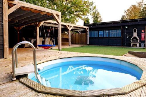 a swimming pool in a backyard with a frisbee at Bohemian Island incl boat supboards and pool 5 minutes by boat from parking to the bohemien in Loosdrecht