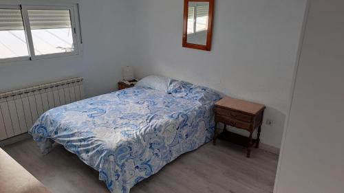 a bedroom with a bed and a table with a mirror at Habitaciones en apartamento compartido de Pozuelo de Alarcón in Pozuelo de Alarcón