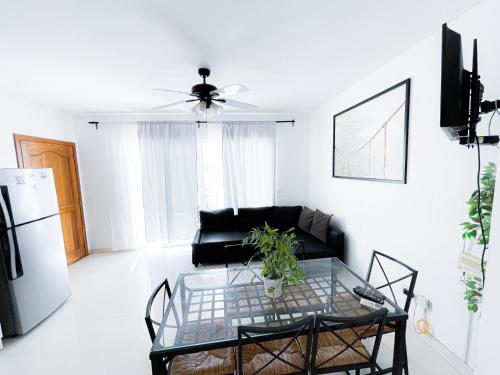 ein Wohnzimmer mit einem schwarzen Sofa und einem Glastisch in der Unterkunft Sunny Seascape Villas & Aparts Hotel WiFi BBQ Los Corales BAVARO BEACH Club & spa in Punta Cana
