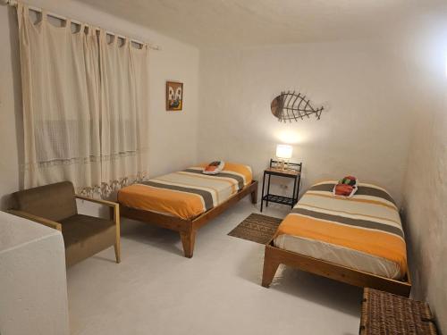 カレタ・デ・ファマラにあるCasa Callaoのベッド2台と椅子が備わる客室です。