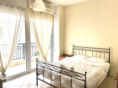 a bedroom with a bed and a large window at City's heart in Agios Nikolaos