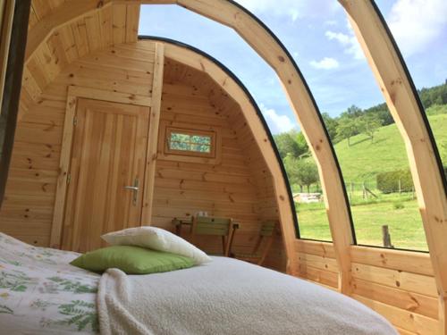 a bedroom with an arched doorway in a wooden cabin at Le Repaire de Mitzerlé in Mitzach