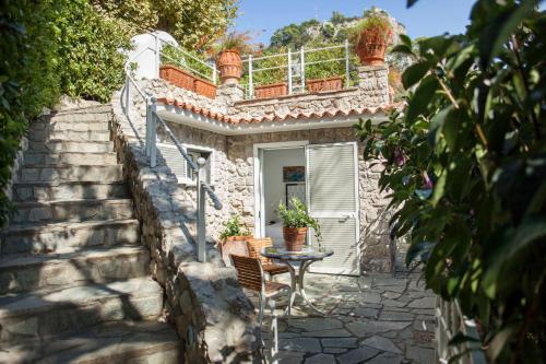 uma casa de pedra com uma mesa e uma varanda em LHP Suite Superior Cottage Capri em Capri