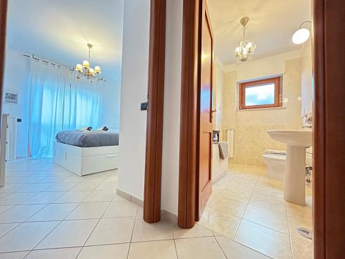 a bedroom with a bed and a bathroom with a sink at Nui Prestige Home in Fiumicino
