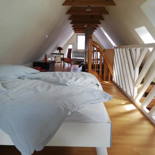 a white bed in a room with a staircase at Ferienhaus im Grünen mit Grillmöglichkeit in Alt Krenzlin