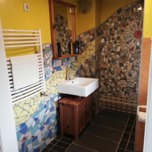 a bathroom with a sink and a mosaic wall at Ferienhaus im Grünen mit Grillmöglichkeit in Alt Krenzlin