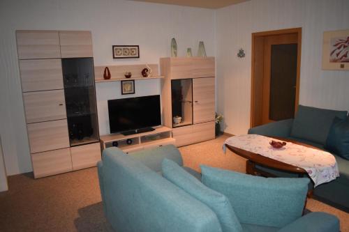 een woonkamer met twee blauwe stoelen en een televisie bij Ferienhaus LIANE 