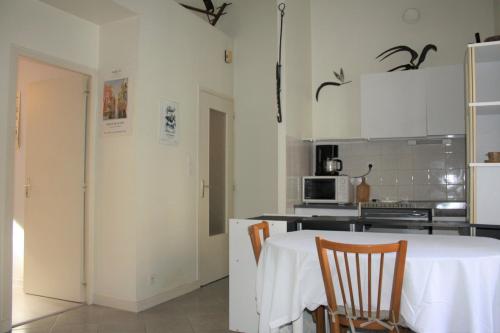 une cuisine avec une table et des chaises dans une pièce dans l'établissement Appartement champêtre - Déconnexion assurée, à Poitiers