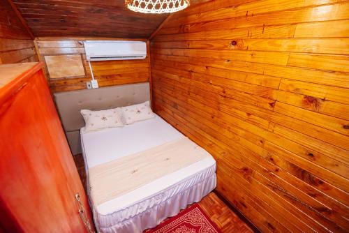 a small room with a bed in a wooden wall at Cabin Renty Beach in Encarnación