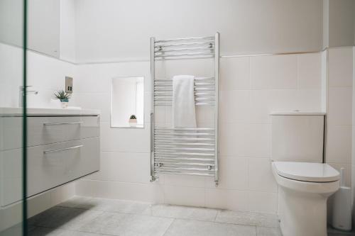 a white bathroom with a toilet and a shower at The Old Granary in Barnetby le Wold