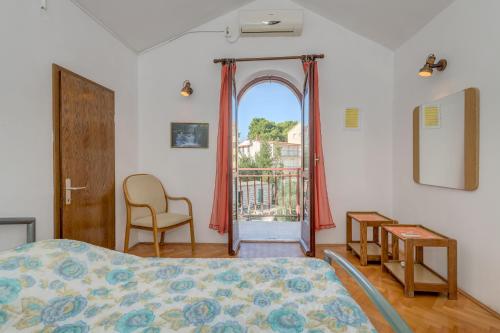 Un dormitorio con una cama y una ventana y una silla. en Apartment Natasa, en Rogoznica