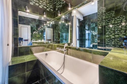 a bathroom with a tub and a mirror at Spiaggia d'oro Apartment Lake View in Montecucco