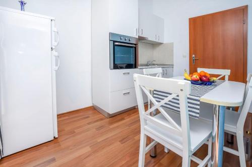 a kitchen with a table with a bowl of fruit at Apartments Vladimir in Primošten