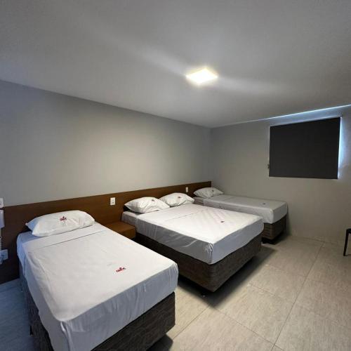 um quarto com 2 camas e uma televisão de ecrã plano em ONIX AGUAS CLARAS em Salvador