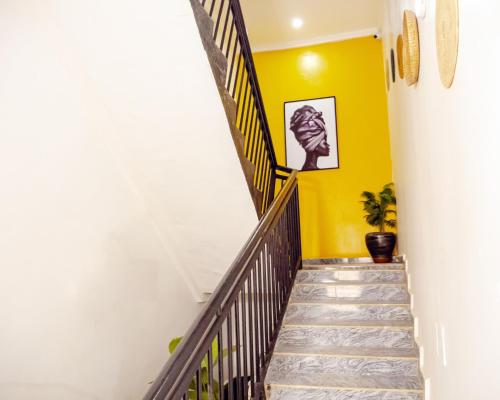 a staircase in a house with yellow walls at Nexus Xpress Hotel in Abuja