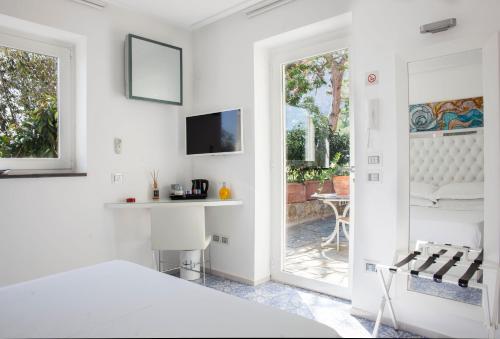 Dormitorio blanco con cama y mesa en LHP Suite Superior Cottage Capri, en Capri