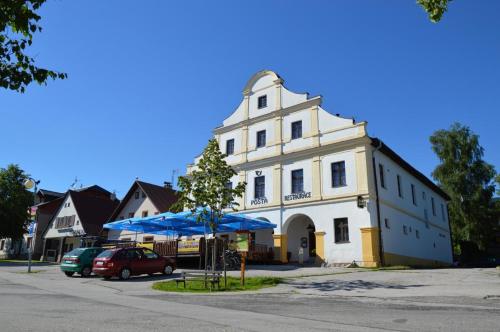 a white building with a blue umbrella in front of it at Horský Apartmán Černý Důl in Lauterwasser