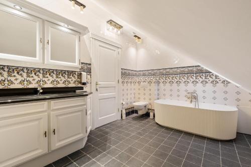 y baño con bañera y aseo. en WijnKasteel Haksberg, en Tielt