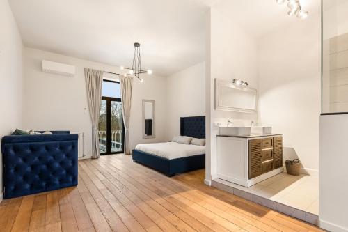 - une chambre avec un lit, un canapé et un lavabo dans l'établissement WijnKasteel Haksberg, à Tielt