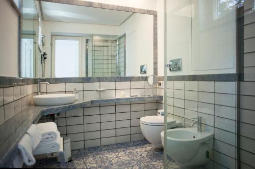 a bathroom with a toilet and a sink and a mirror at LHP Suite Superior Cottage Capri in Capri